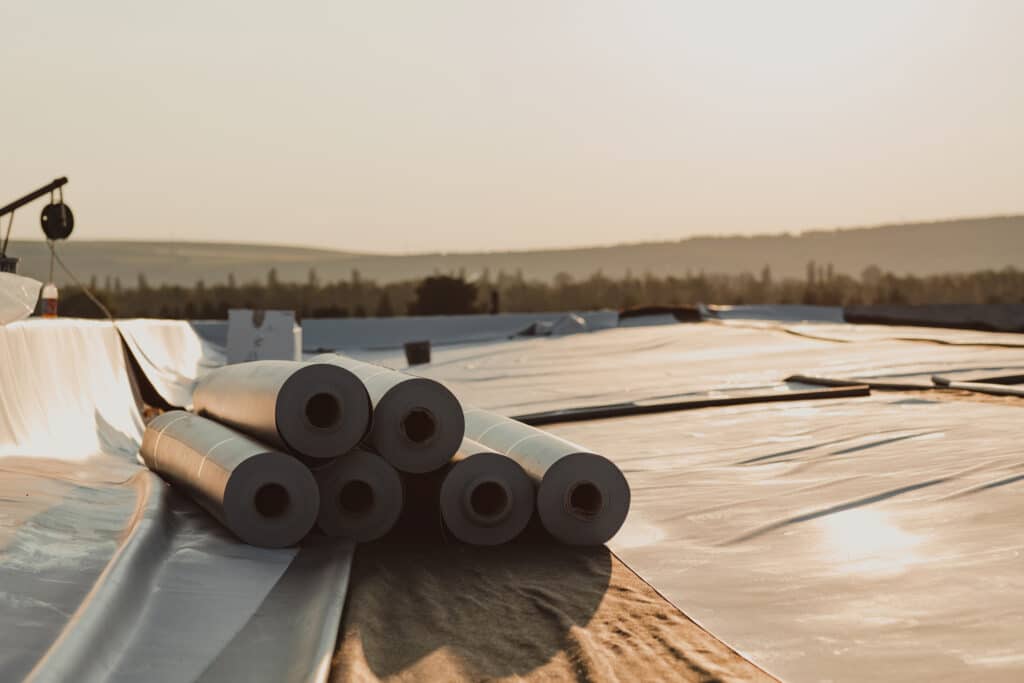 Membrane de toiture PVC en rouleaux posée sur le toit d'un hall. Membrane en caoutchouc prête.