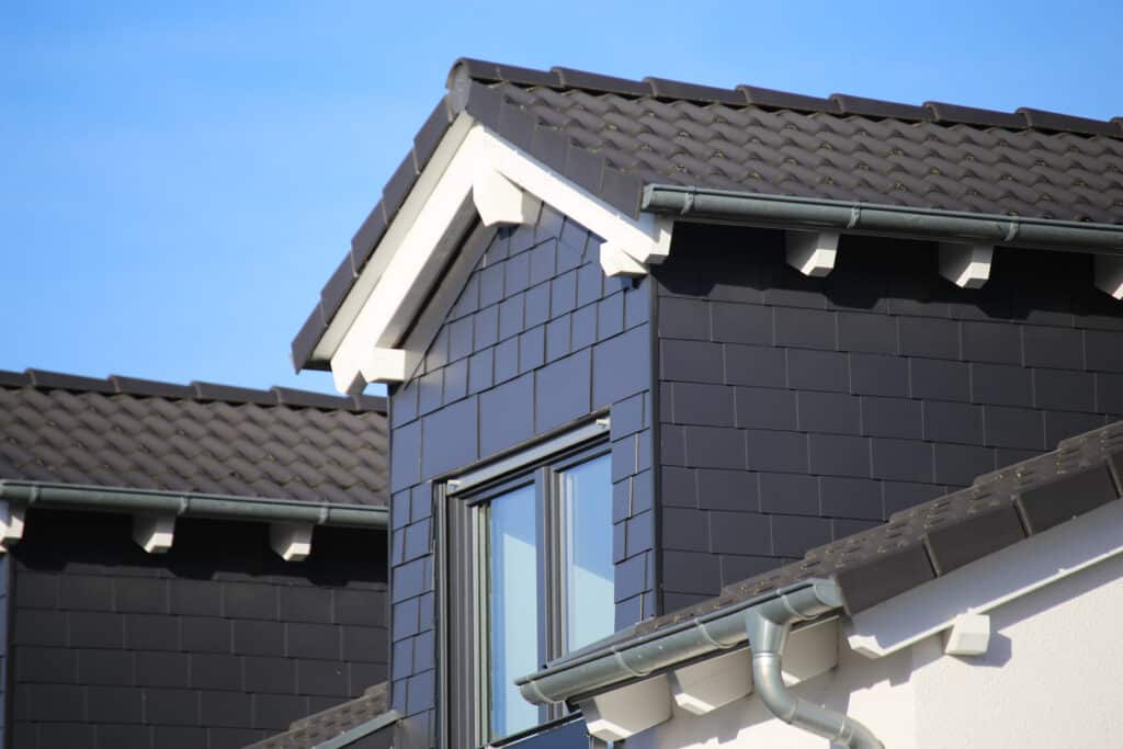 Lucarne recouverte d'ardoise sur un nouveau toit de tuiles